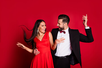 Photo of funny optimistic couple dancing wear suit dress isolated on red color background