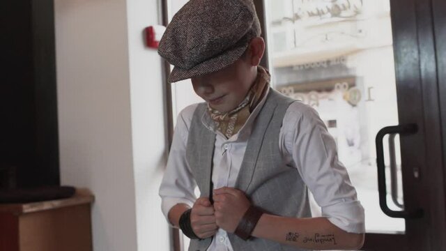 Young stylish gentleman in a cap enters a barbershop