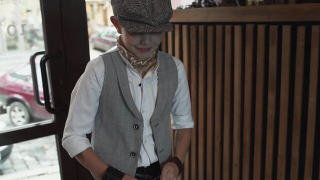 Young stylish gentleman in a cap enters a barbershop