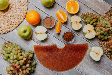Fototapeta na wymiar Grape fruit leather with fresh fruits on the wooden table. Round fruit leather. Healthy food. Apples, bananas, grape top view. Grape fruit without sugar.