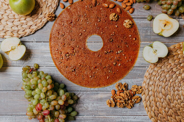 Grape fruit leather with nuts on the wooden table. Round fruit leather. Healthy food. Apples, bananas, grape top view. Grape fruit without sugar.