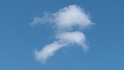 Obraz premium Two clouds look like a scene from life. In the clear blue sky, there are two clouds, one above the other. The clouds are like a falcon carrying a caught fish in its talons.