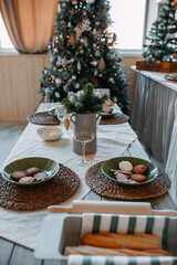 Christmas decorations. Fir branches with snow inside the vase on the christmas table. Decoration of festive table for christmas eve. Festive dish for new year eve.