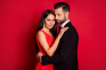 Photo of positive lady guy hug dance closed eyes enjoy moment isolated on bright red color background