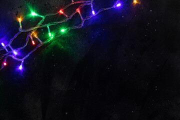 Christmas banner background. Glowing Christmas tree garland on dark background. Copy space. Festive background.