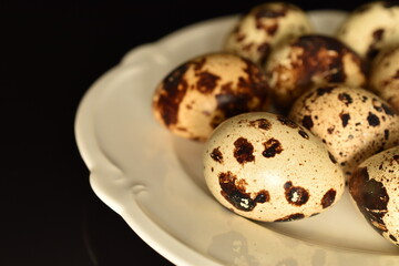 Fresh quail eggs, close-up, isolated on black.