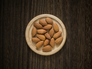 Almonds in a bowl of wood. Nuts in a bowl on the table of wood.  