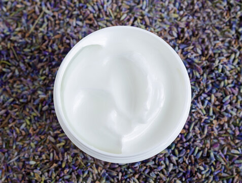 White facial mask (face cream, shea butter, hair mask, body butter) in the small white container. Natural skin and hair concept. Top view, copy space.