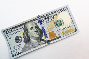 textured background of one hundred dollar bill with a portrait of us President Franklin in orange, red and black colors. blur, defocus.