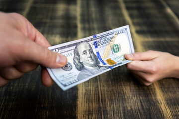 textured background of one hundred dollar bill with a portrait of us President Franklin in orange, red and black colors. blur, defocus.