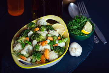 Bowl of fresh vegetable salad on dark wooden background.Broccoli, carrots, cauliflower. Vegetable Salad.