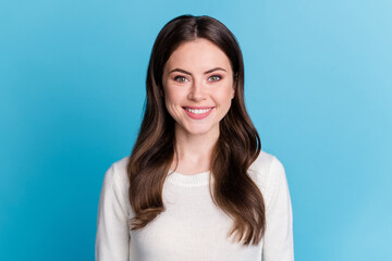 Obraz premium Photo of adorable sweet wavy lady wear white sweater smiling isolated blue color background