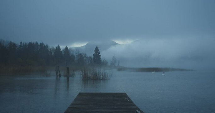 Mist is rising during a foggy break of dawn, while winter is coming over the countryside of lake Mondsee, Austria