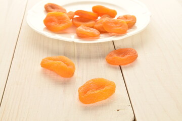 Bright orange natural dried apricots, close-up, on a wooden table.