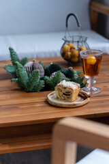 Piece of brioche with maple syrup and hot punch in a glass on table. Cozy place on the loggia