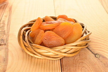Bright orange natural dried apricots, close-up, on a wooden table.