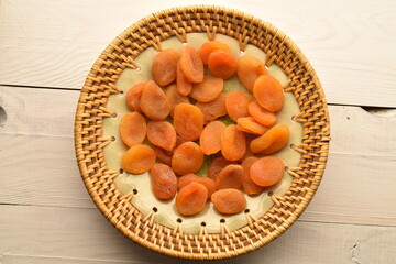 Bright orange natural dried apricots, close-up, on a wooden table.
