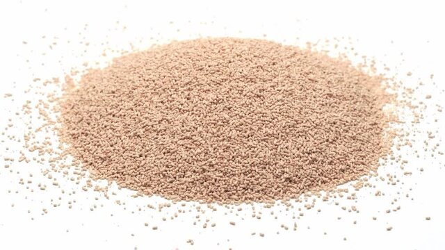 Close-up view of a heap of dried active yeast, isolated on white, seamless loop rotation