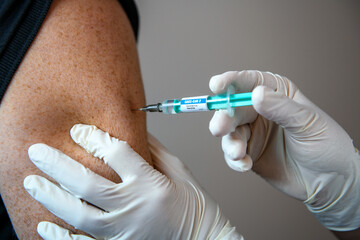 Wuppertal, 04.12.2020, Impfung im Oberarm gegen das Coronavirus SARS-CoV-2 mit Spritze und...