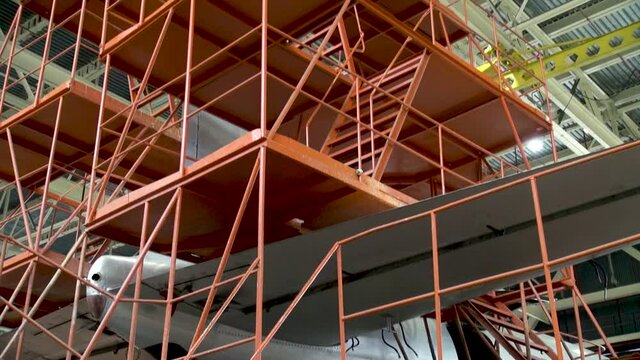 Technological slipways and stepladders for repairing tail of Il-18 aircraft. Maintenance of four-engine long-range passenger aircraft Il-18 in hangar. Era of Soviet aviation. Vintage video.