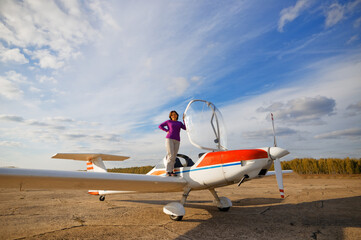 girl on the wing of a glider airplane on the runway