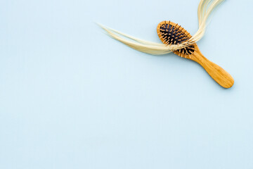 Female blond hair wirh bamboo brush, flat lay