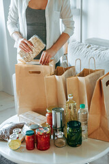 Woman packing food for donation in paper bag