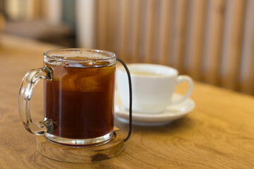 ice coffee with hot tea on wood table.