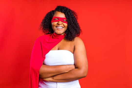 Spanish Woman In Eye Mask And Superhero Cloak In Red Studio Background