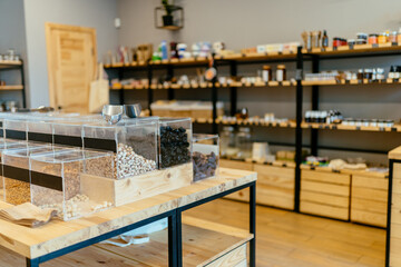 Zero waste shop interior. Wooden shelves with different food goods and personal hygiene or...