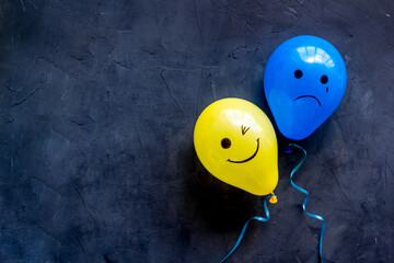 Positive and negative emotions background. Sad and happy faces on ballons