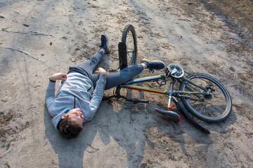 Spring in a pine forest boy fell off his bicycle.