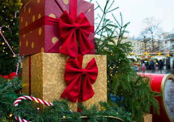 Beautiful colorful gift boxes at the street Christmas market. Christmas and New Year decorations on the festive winter fair. Concept of celebration and presents