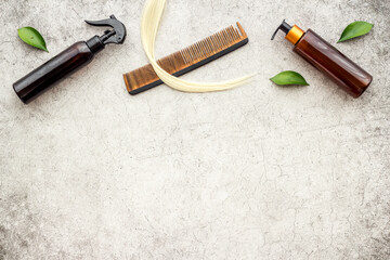 Female hair with care products and wooden comb, top view, flat lay