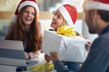 male colleague gives presents to female coworkers for christmas