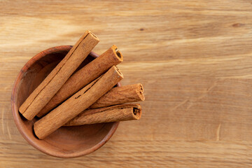 Cinnamon sticks in a wooden bowl.