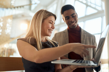 Female employee explaining a job task to a colleague at company's hallway. People, job, company, business concept.