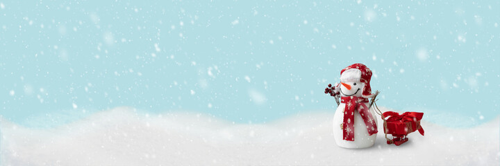 Banner 3:1. Happy snowman sledding gift box on sleigh in winter christmas landscape. Merry christmas and happy new year celebration concept