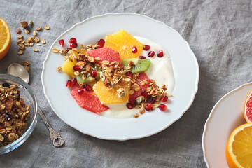 Breakfast plate with colorful citruses, yogurt and homemade granola 