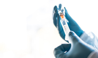 The doctor prepares the syringe with the cure for vaccination.