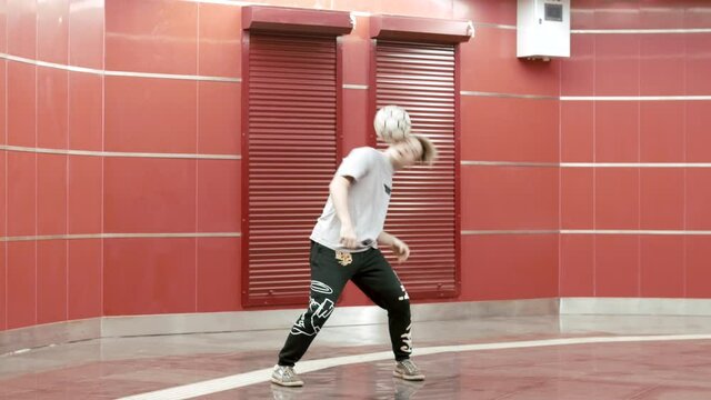 Football freestyle. Teenager guy football soccer player practicing tricks, kicks and moves with ball. Professional football freestyler athlete stuffing kicking the ball and making cool tricks. Sport