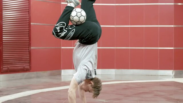 Football freestyle. Teenager guy football soccer player practicing tricks, kicks and moves with ball. Professional football freestyler athlete stuffing kicking the ball and making cool tricks 