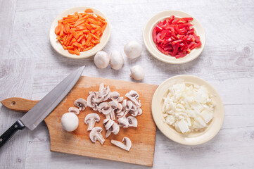Preparing a meal on a wooden table, cut vegetables