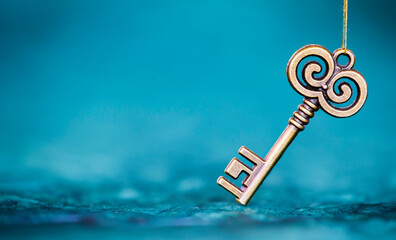 Vintage gold key on blue background, life coaching, solution or self realization concept