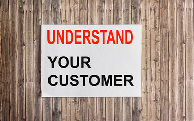 Close up on card text UNDERSTAND YOUR CLIENT, image business concept on wooden background