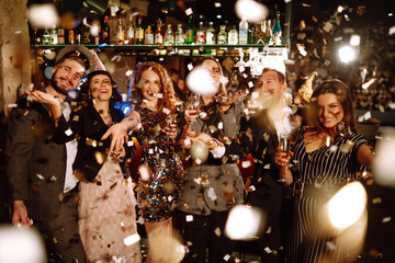 Confetti party. Have fun together. Group of happy people throwing confetti while enjoying party. Holiday, celebration, drink, birthday concept.