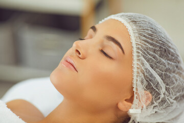 Close-up of womans face relaxing with eyes closed after skincare procedure or massage