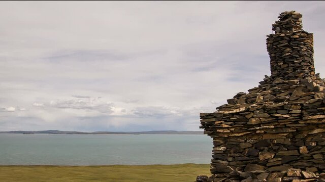 Scenic tibetan highland landscape with buddhist stupa, clouds and mountains in skyline. Source of Yellow River (Huang He). Tibetan Plateau in Qinghai Province, Amdo region, China. 4K UHD timelapse.