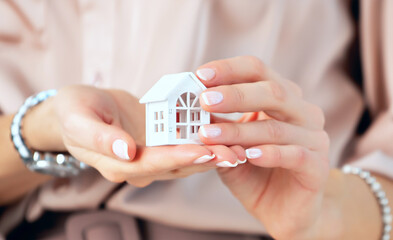 Sale and insurance of the house, hands protect the house. Concepts for real estate and residential...