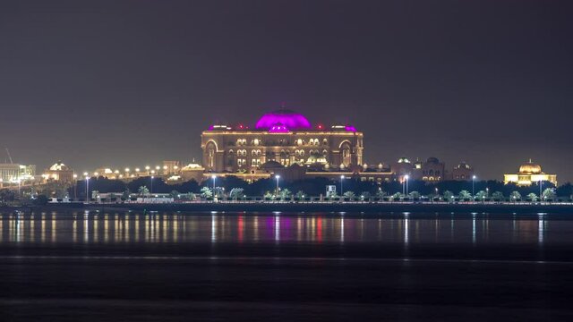 Emirates Palace illuminated at night timelapse, Abu Dhabi, United Arab Emirates. Lights reflected in water